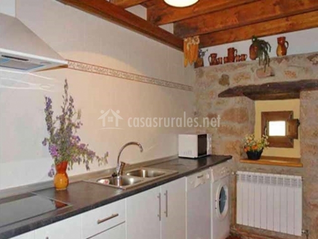 Cocina con muebles blancos y techo de madera Cocina con muebles blancos y techo de madera